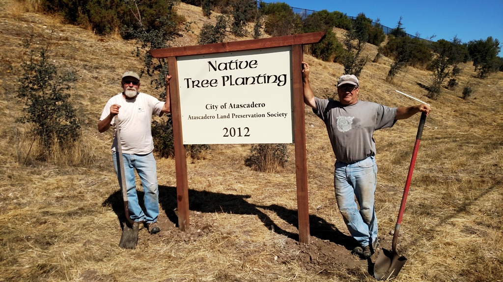 Cory and Mike next to the new sign at the Alondra Road planting site.